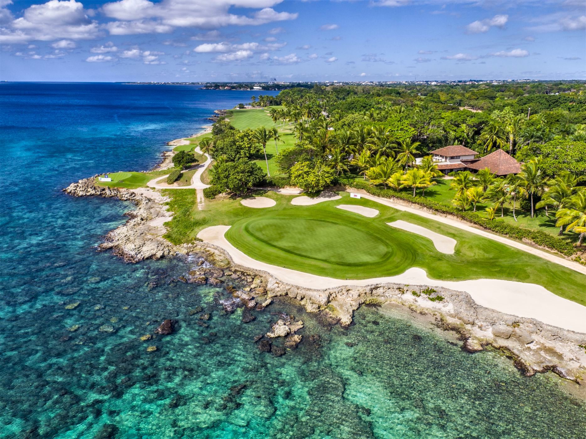 Aerial view of a Teeth of the Dog green on the Caribbean shore, the golf a package price comparison often leaves out