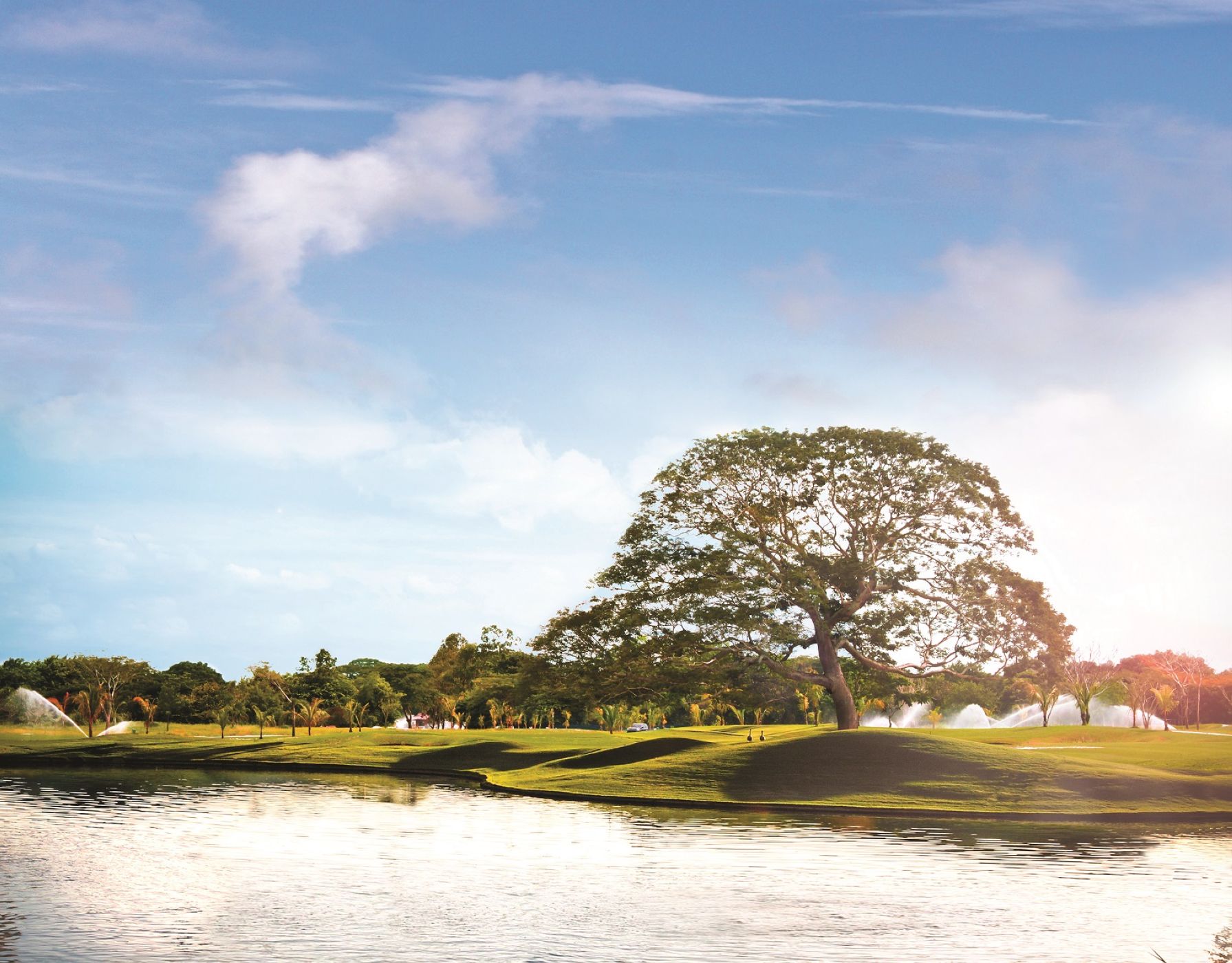 Calle y lago del campo de Buenaventura en una mañana despejada: la temporada de golf en Panamá dura todo el año